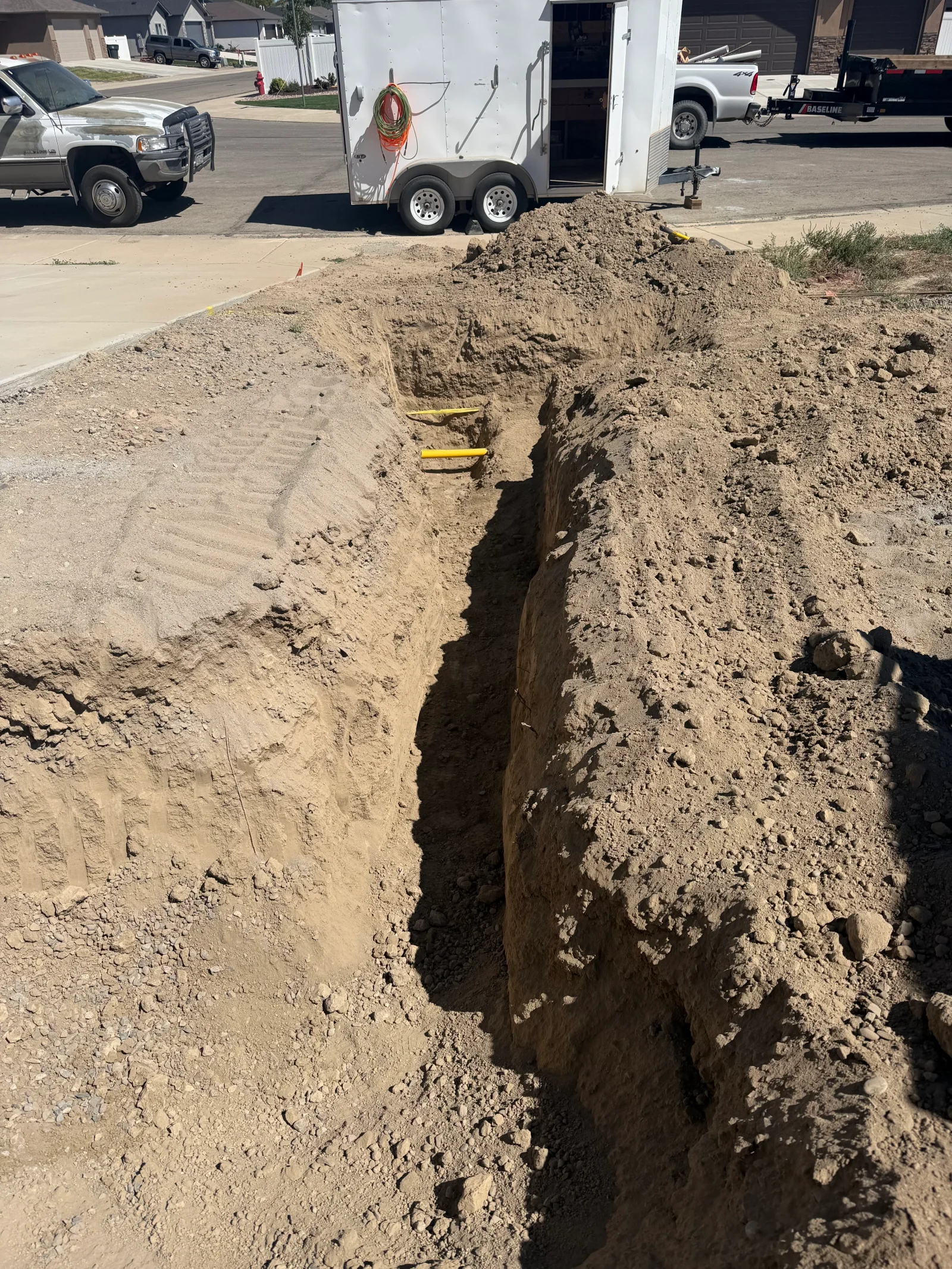 Deep utility trench excavation showing soil layers and vertical cut walls
