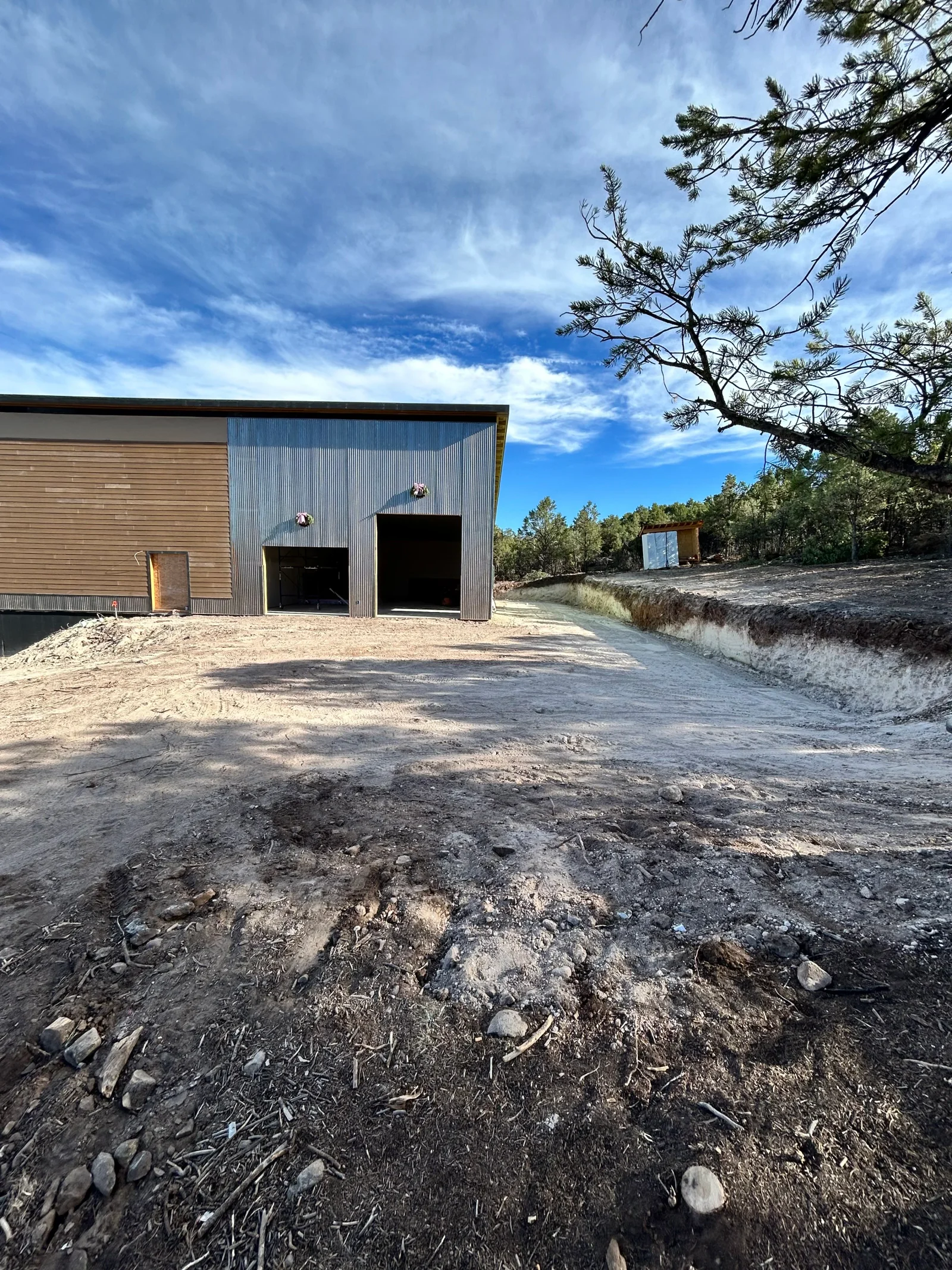 Cleared demolition site with metal and wood building debris removed, graded dirt foundation exposed