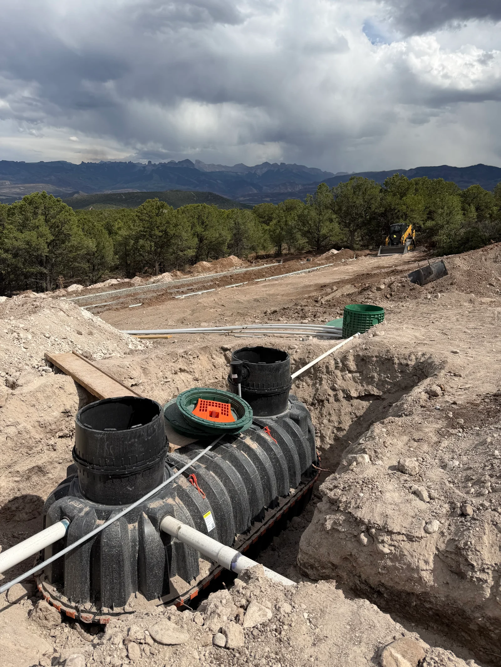Underground septic tanks with access ports and PVC drainage pipes installed in excavated soil